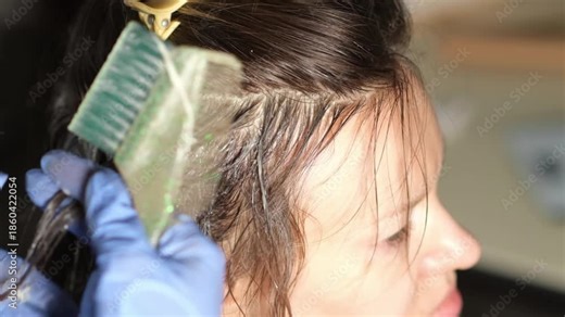 Step-by-step hair coloring process demonstrates techniques for achieving vibrant color. A skilled stylist applies dye with precision and care.