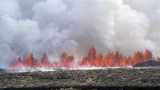 An Iceland volcano spews red streams of lava toward an evacuated town