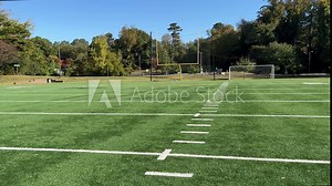 Green synthetic turf field on a clear autumn day with a shallow depth of field and copy space