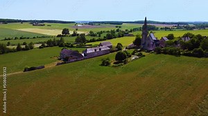 Poppies field in a typical countryside with a church in France