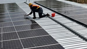 Technician installing solar panels on a rooftop, demonstrating renewable energy solutions for sustainable development, clean energy, and eco-friendly technology in modern infrastructure