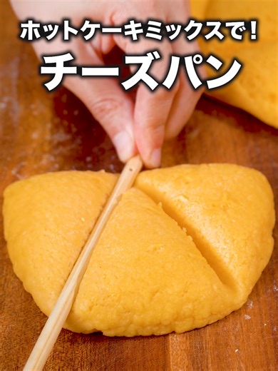 オーブンも発酵もなし！「オムレツチーズパン」 #パン #チーズパン #手作りパン #tiktokレシピ #料理動画 #デリッシュキッチン #DELISHKITCHEN 詳しくはデリッシュキッチンアプリで「オムレツチーズパン」と検索🔍 ■材料 (2個分) ・卵(Mサイズ) 1個 ・ホットケーキミックス 200g ・溶かしバター(無塩) 10g ・プレーンヨーグルト(無糖) 大さじ1 ・とろけるスライスチーズ 2枚 ■手順 (1)ボウルに卵、ヨーグルトを入れて泡立て器で混ぜる。 (2)1に溶かしバターを入れて混ぜ、ホットケーキミックスを加えて粉っぽさがなくなるまでゴムベラで混ぜる。 (3)生地が滑らかになるまでこねたら、2等分にして丸めて、めん棒でだえん形に伸ばす。(焼く際に火が通りにくくなるため、生地を伸ばす際は厚くなりすぎないように5〜7mm程度まで伸ばしましょう。) (4)4の下半分にとろけるチーズを半分に折ってのせ、半分に折り半円形にして閉じ口を止めたら菜箸などで模様をつける。 (5)オーブンシート(クッキングシート)を敷いたフライパンに並べ、弱火で両面5分ずつ焼く。(生地を伸ば
