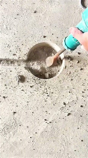 Rotary hammer with chisel bit chips into concrete surface releasing fine dust