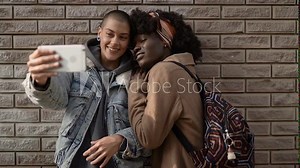 Diverse young lesbian couple taking a selfie outdoors