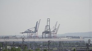 Shipping container cranes at dock pier in Brooklyn New York along harbor. Longshoremen operate heavy machinery for international trade cargo