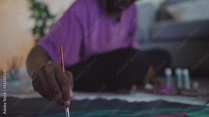 Young African woman drawing picture at home
