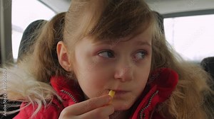 Child girl eating in the car french fries fast food