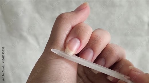 A woman files her fingernails with a file. Hand nail care. Natural manicure
