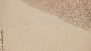 Close-up shot of sand. The texture of sand, grains of sand fly blown away by the wind.