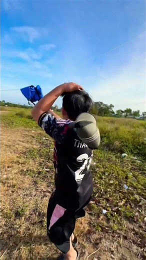 Flying kites, the older brother holds a huge roll of string while the younger brother lowers the ...