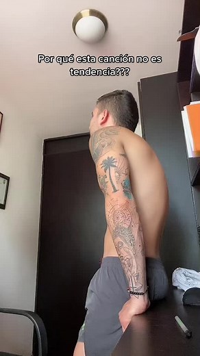 Muscular Male Tattoo Showcase in Dark Room