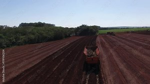 Mechanized planting sugar cane field in Sao Paulo Brazil - Aerial dolly out following tractor planting sugar cane field - sugar cane plantation