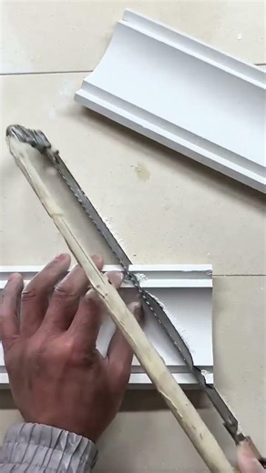 “Hand saw slices crown molding, angled cut reveals perfect corner fit…”