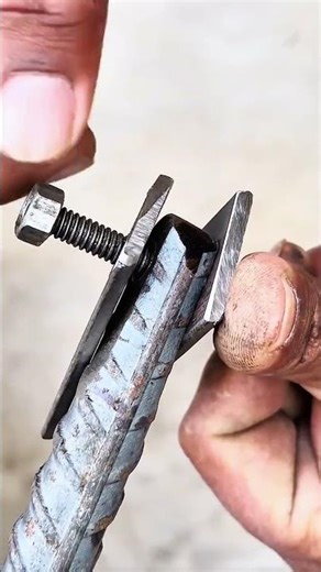 Threaded metal rod secured by clamp on machinery base