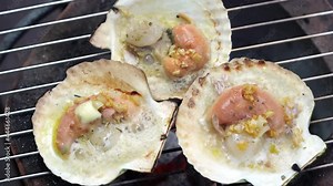 Grilled scallops shell with butter and garlic, Grilled scallops on a hot charcoal stove.