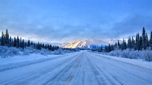 The frozen road passing through Yukon’s mountain landscape