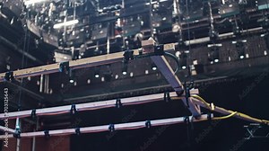 A special effects rain machine in a film cinema studio with a ceiling full of film lights. High shot of water dripping to reveal a good view of construction of the hoses and wooden frame. Stock Video