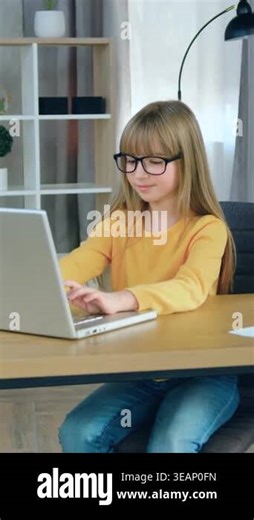 Likable smiling confident modern 10-aged girl in glasses sitting at her workplace in front of computer and doing her homework school education concept Stock Video Footage - Alamy