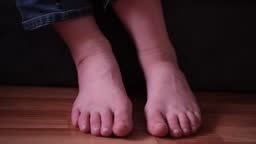 Close up of barefoot teenage boy playing with his feet. child rolls...