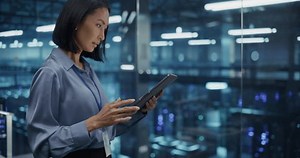 Portrait of an Asian Female Manager Studies Online Reports on Her Tablet Computer, Standing in a Modern Data Center with Server Systems. Young Woman Searching for Patterns to Improve Production