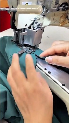 sewing dark green fabric using a professional industrial machine to create a strong flatlock seam