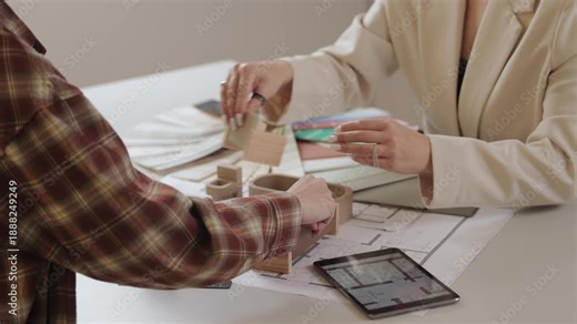 Presentation of design interior, Female designer with client discussing color samples and 3d models at work desk.