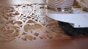 Woodworking CNC router machine cuts a pattern on a piece of wood.Close up,slow motion.