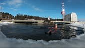 A man swiming in an ice hole in winter. Winter swimming is a...