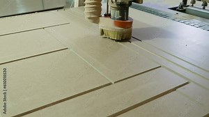 The MDF machine turns over the panels. The machine grinds a wooden panel in a furniture production. Processing panels on a coordinate milling woodworking machine with CNC.