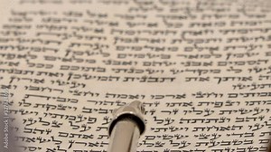 Torah bible reading text with pointer. Aramaic and Hebrew letters from holy book Zohar or Kabbalah. Close up shot on sacred spiritual texts