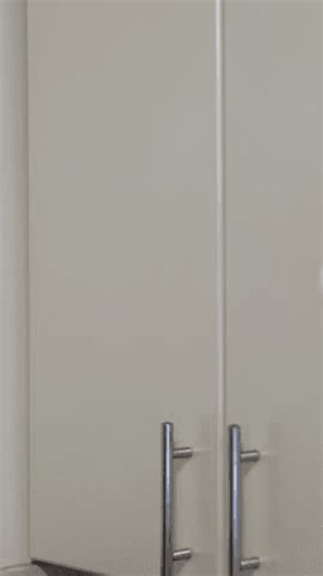 clip-3990827927-woman-pink-robe-opens-sleek-white-kitchen