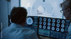 In Medical Laboratory Patient Undergoes MRI or CT Scan Procedure, in Control Room Doctor and Radiologist Discuss Diagnosis while Watching Procedure and Monitors Brain Activity