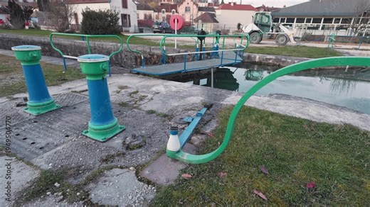 Montbard, France — March 5, 2026: A view of a traditional canal lock mechanism on the Burgundy Canal. The footage captures the historic engineering and water level control system.