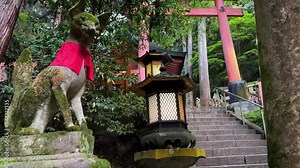 Fox statue at Fushimi Inari with Japanese decorations in background