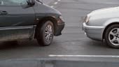 Slow motion wide handheld shot of two cars crashing into each other...