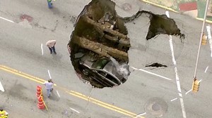Woman survives sinkhole drop