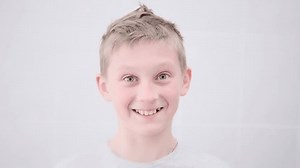 teenage blond boy brushing teeth with an electric brush on a white background. Fun lifestyle. Children smile. hygiene, health care, dental. play dentist game, daily morning procedures