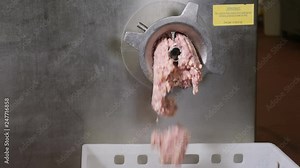 Industrial sausages production process at meat and sausage processing plant. Meat factory equipment. Sausage production line. Huge meat grinder mincer machine produces minced meat. 4k