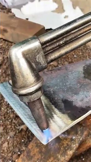 Using a metal gas, torch to heat a thick metal plate on the ground until it glows with a blue flame.