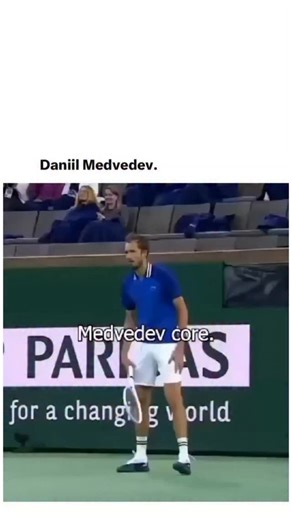 deadshoteditz on Instagram: "The image captures a humorous, slightly awkward moment during a professional indoor tennis match. A tall male tennis player stands near the baseline on a hard court, wearing a blue short-sleeve shirt, white shorts, white crew socks, and dark tennis shoes. He is mid-motion, adjusting his shorts with both hands, which gives the scene an unintentionally comic feel. His posture is relaxed rather than focused, as if caught between points rather than actively playing. Behi