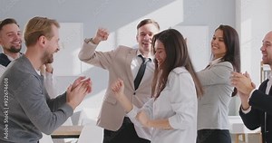 Group of a business young people men and women having fun in the office happy to make a good deal. Company employees celebrating success congratulating female colleague. 4k video. Slow motion video.