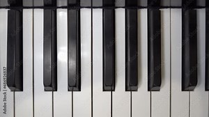 A self-playing piano, also called a pianola, with black and white keys playing a tune automatically.