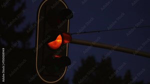 Traffic light works at night time. Close up. Full cycle from green to red signal. Regulations and driving safety concept. Night city traffic control
