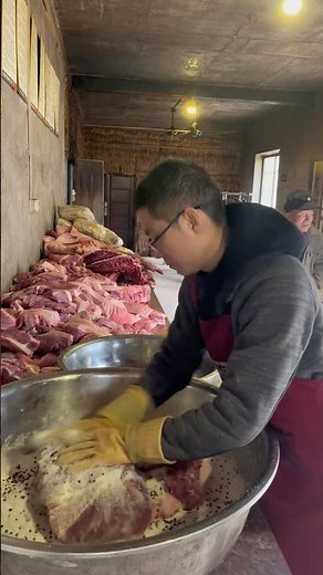 Rub salt onto the pork in preparation for making cured pork.