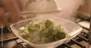 Close-up of cooking turnip greens. Good boiled turnip greens are drained and placed in a glass saucer to be cooked. Hot steam and vegetables in an italian kitchen.