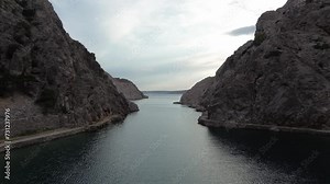 Scenic Drone Flight: Flying from a Lagoon into the Open Sea on an Overcast Day, Surrounded by Mountains