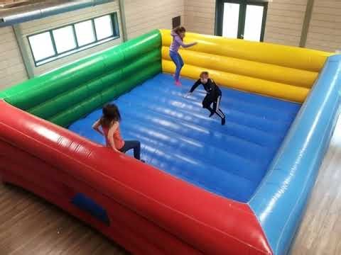 AI Young adults bouncing in a colourful bouncy castle