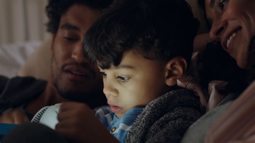 Cute little boy using tablet computer happy mother and father watching child playing games on touchscreen technology having fun before bedtime | Premium Stock Video Footage