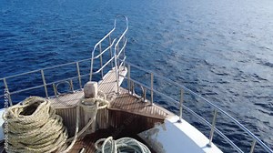 Safaga, Hurghada, Egypt - December 2021: Excursion yacht sails on the red sea with mountains in the background.