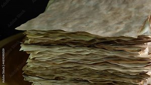 Ancient parchment papers rotation on the wood table, old weathered burnt textured paper stockpile supply. Paper for calligraphy memoir records and book making. Selective focus.